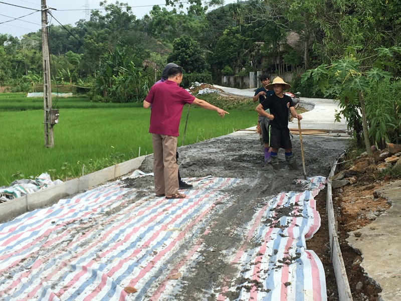 Ông Hoàng Văn Chản (áo đỏ) Chủ tịch UBMTTQ xã đang giám sát thi công tuyến đường thôn Hùng Tiến